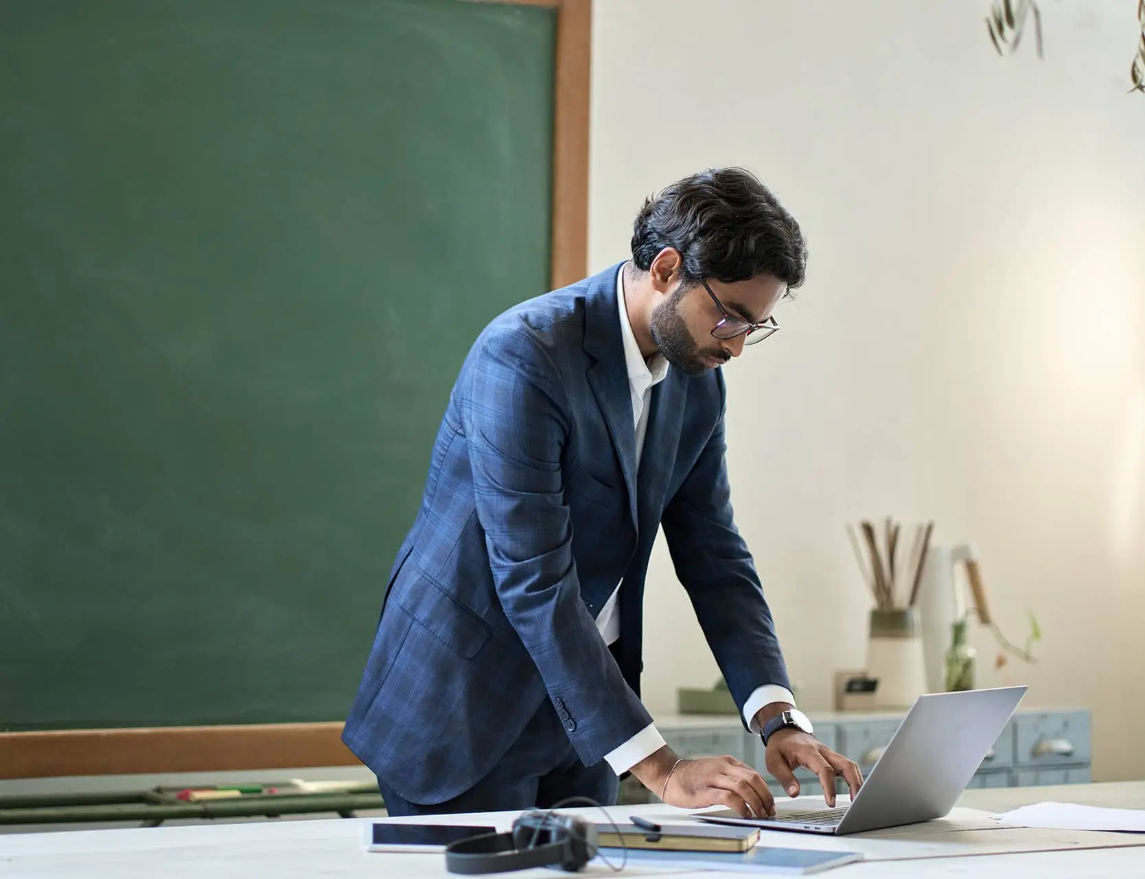 A man standing up working on his laptop
