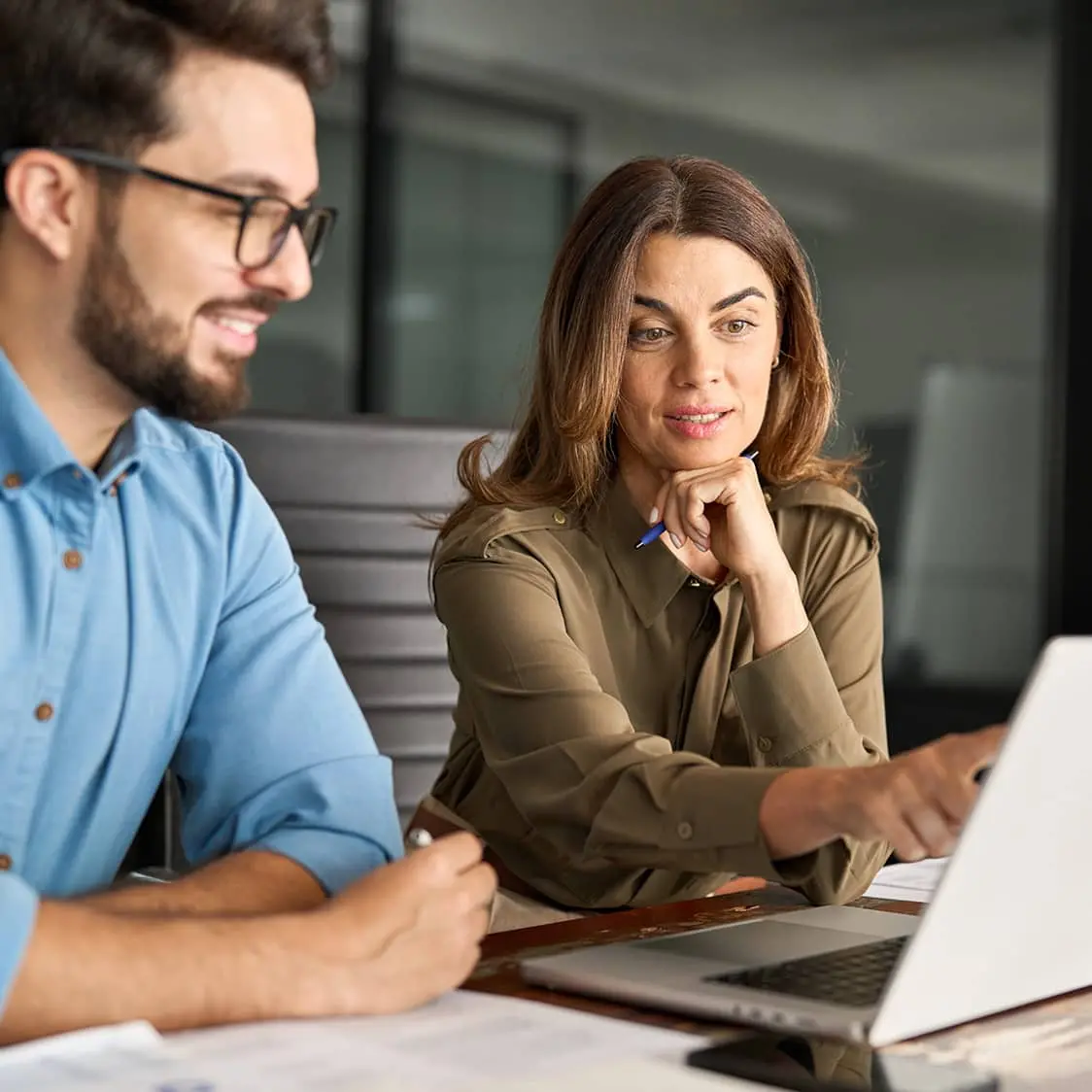 A man and a woman looking at a laptop
